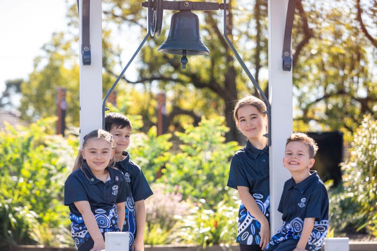 Students surrounding the old bell
